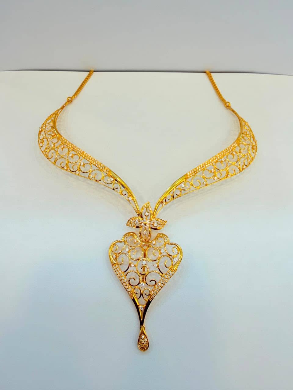 Gold filigree bridal necklace with a heart-shaped stone-set pendant