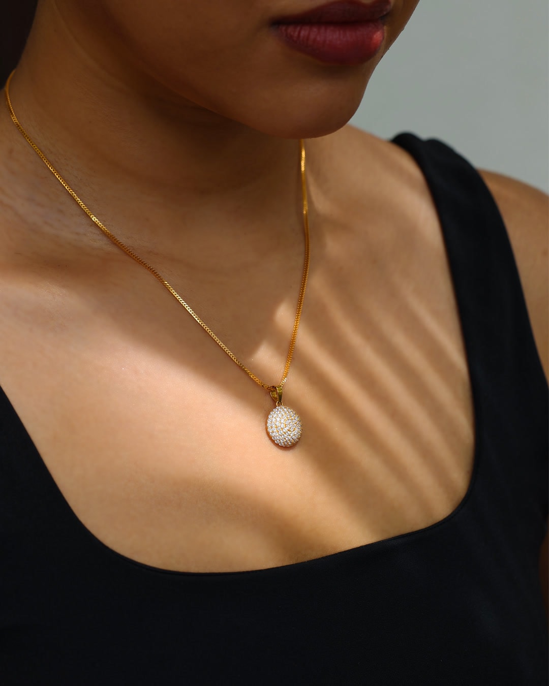 Delicate gold necklace worn at golden hour